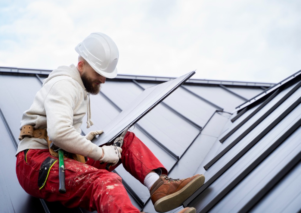 man sitting and working on a roof