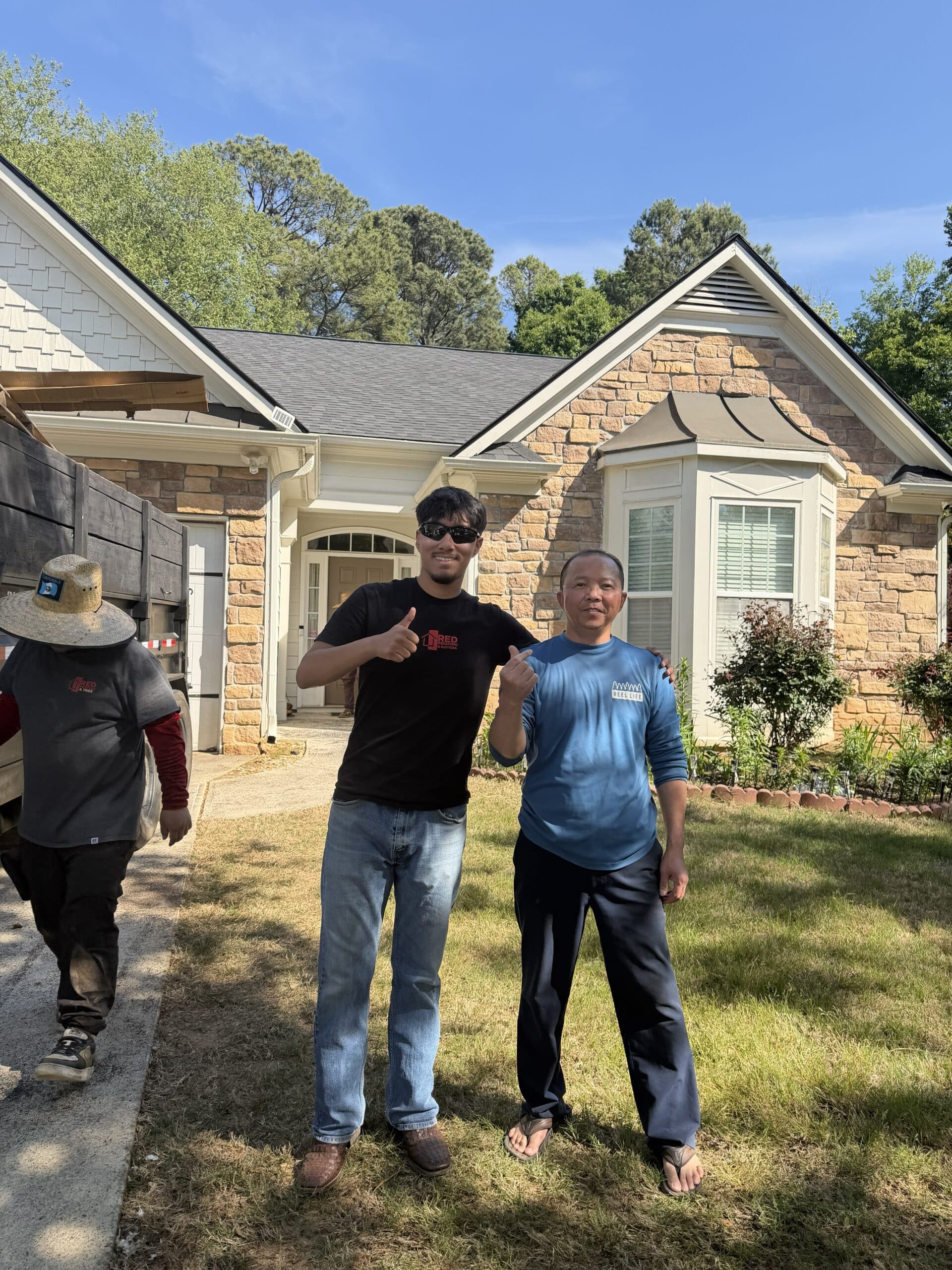 Red Roofing crew member with a satisfied homeowner after a completed roof replacement