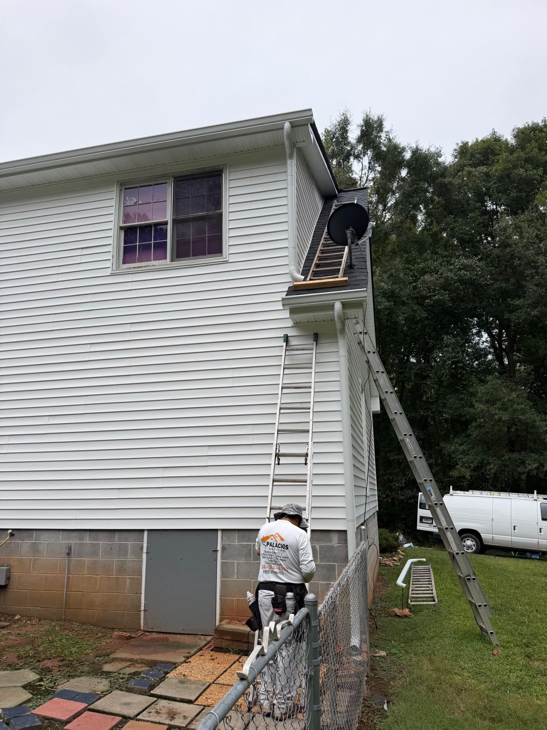 Vinyl Siding Atlanta Ga 2 Vinyl siding Atlanta GA installer on a ladder finishing white lap siding near the roofline