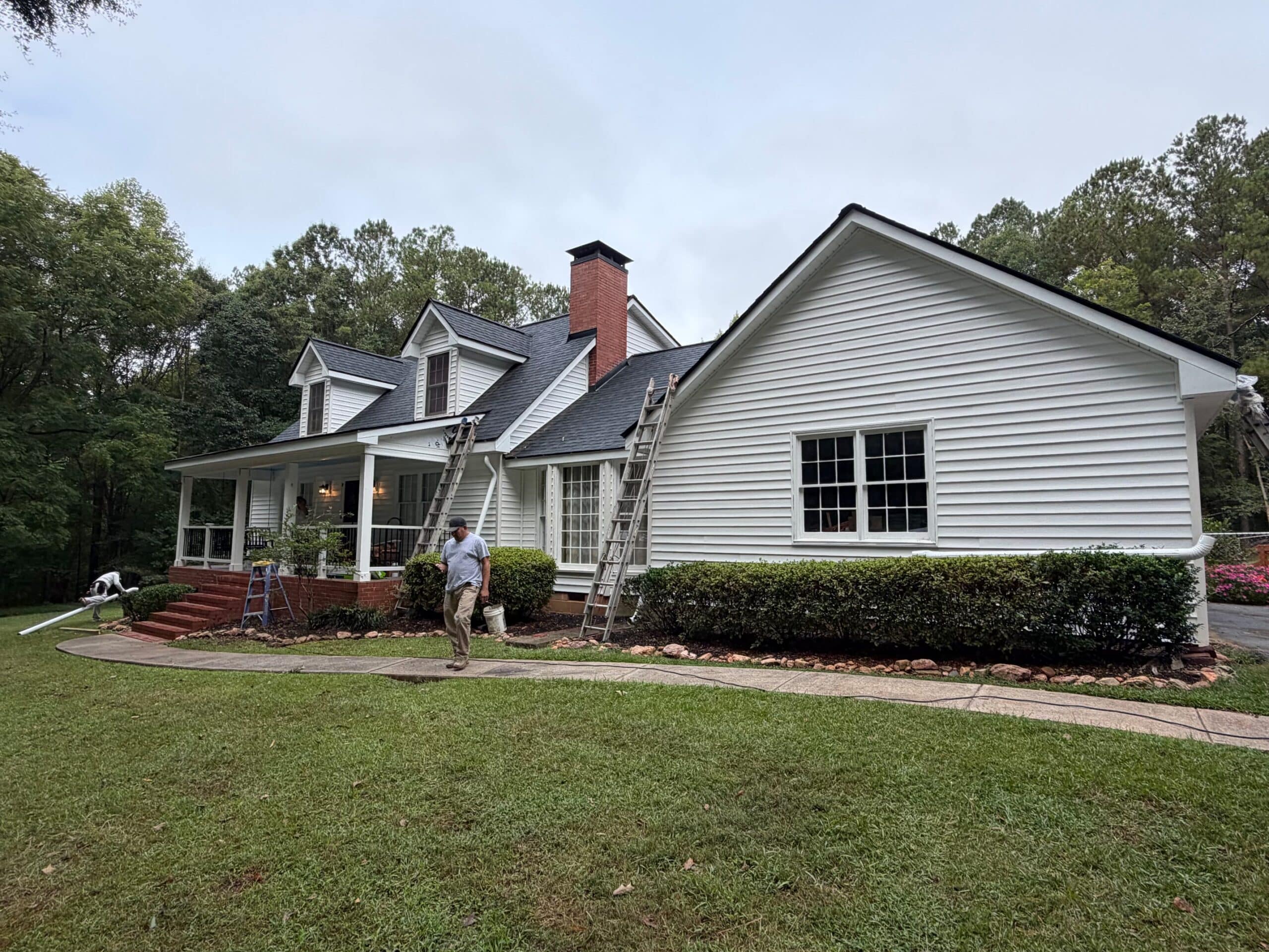 Vinyl Siding Lake Oconee 2 Vinyl siding Lake Oconee project: crew finishing lap siding on a two-story home with dormers